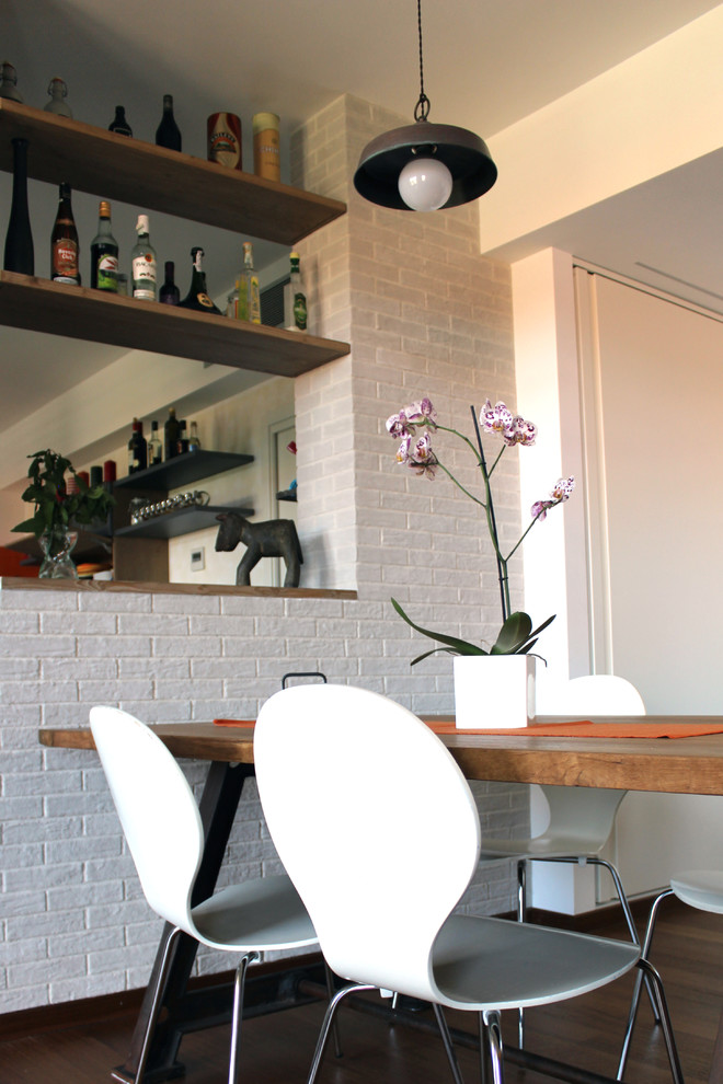 Immagine di una sala da pranzo aperta verso il soggiorno industriale di medie dimensioni con pareti grigie e pavimento in legno massello medio