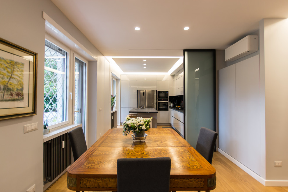 Inspiration for a contemporary dining room in Rome with grey walls and light hardwood flooring.