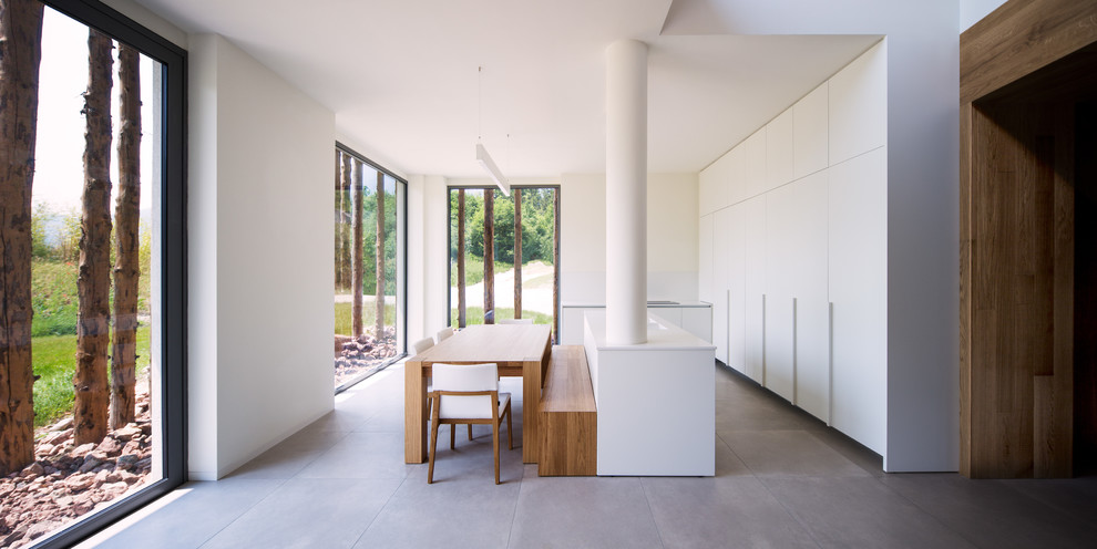 Esempio di un'ampia sala da pranzo aperta verso la cucina stile rurale con pareti bianche, pavimento in gres porcellanato e pavimento grigio
