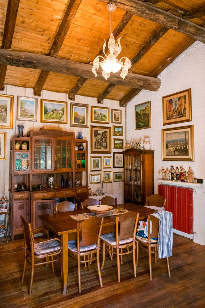 Cette image montre une salle à manger bohème avec un mur blanc, parquet foncé et un sol marron.