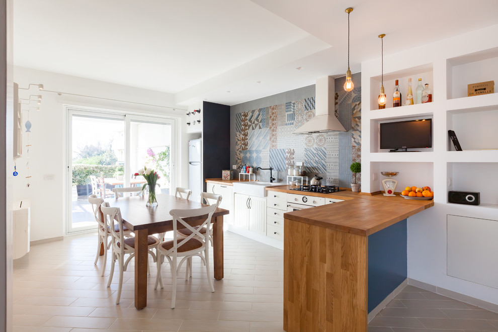 Immagine di una sala da pranzo aperta verso la cucina stile marino di medie dimensioni con pareti bianche e pavimento con piastrelle in ceramica
