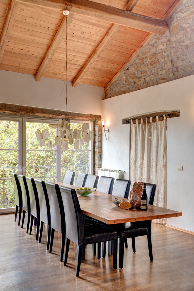 Exemple d'une grande salle à manger ouverte sur la cuisine tendance avec un mur blanc, un sol en bois brun et un sol marron.