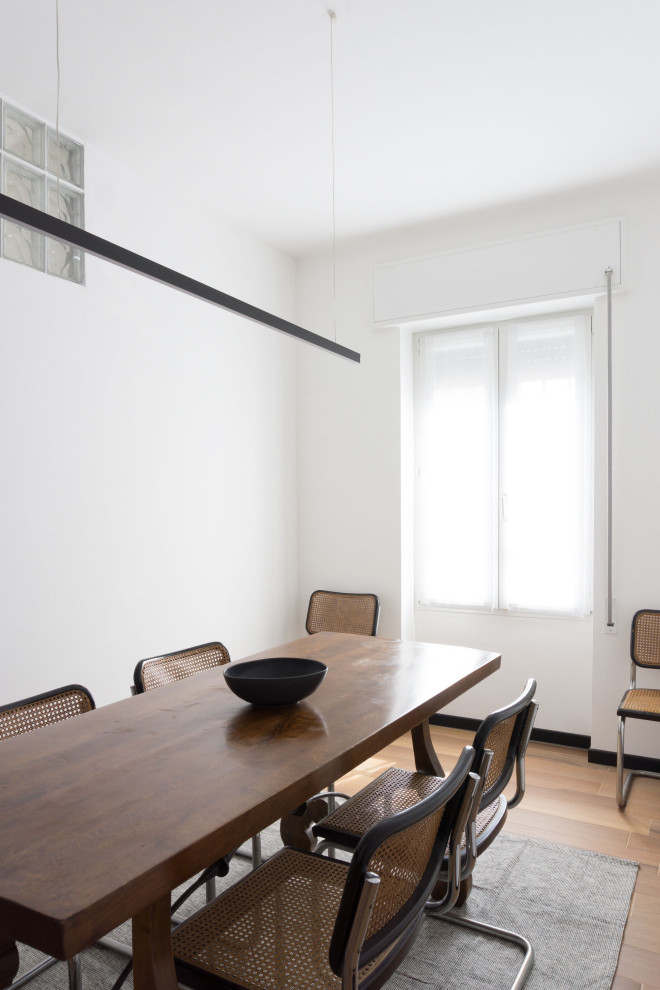 Idee per una piccola sala da pranzo minimal chiusa con pareti bianche, pavimento in gres porcellanato e pavimento marrone