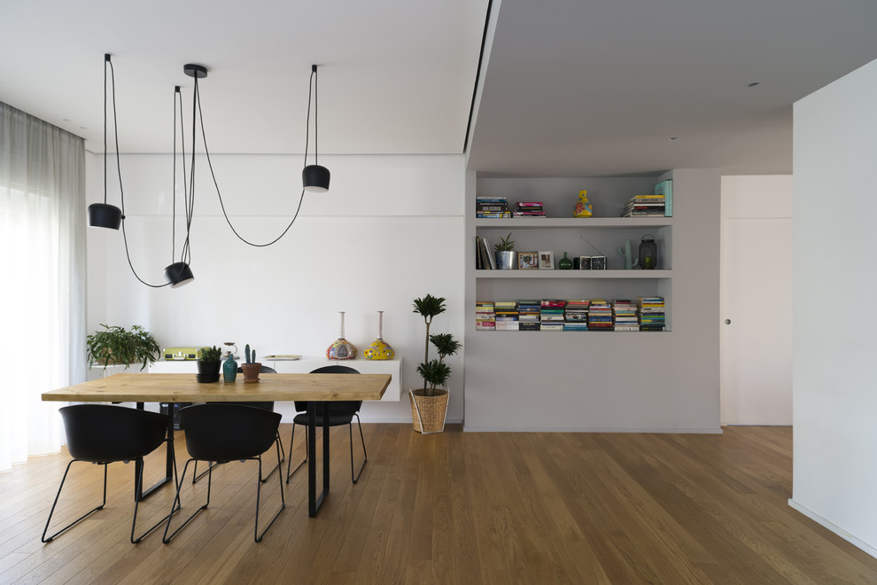 Exemple d'une salle à manger tendance avec un sol en bois brun, un mur blanc et un sol marron.