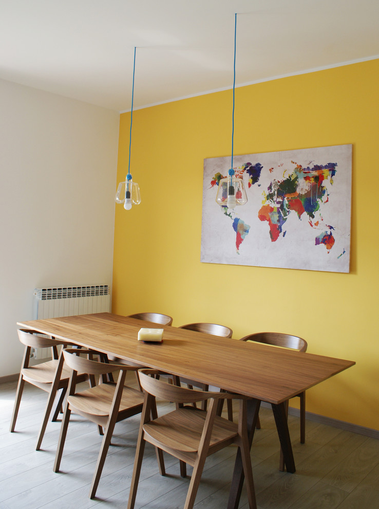 Immagine di una sala da pranzo nordica con pareti gialle e parquet chiaro