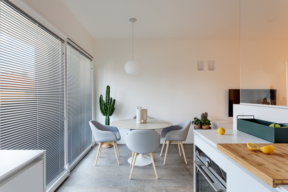 Idee per una sala da pranzo contemporanea con pareti bianche, pavimento in gres porcellanato e pavimento grigio