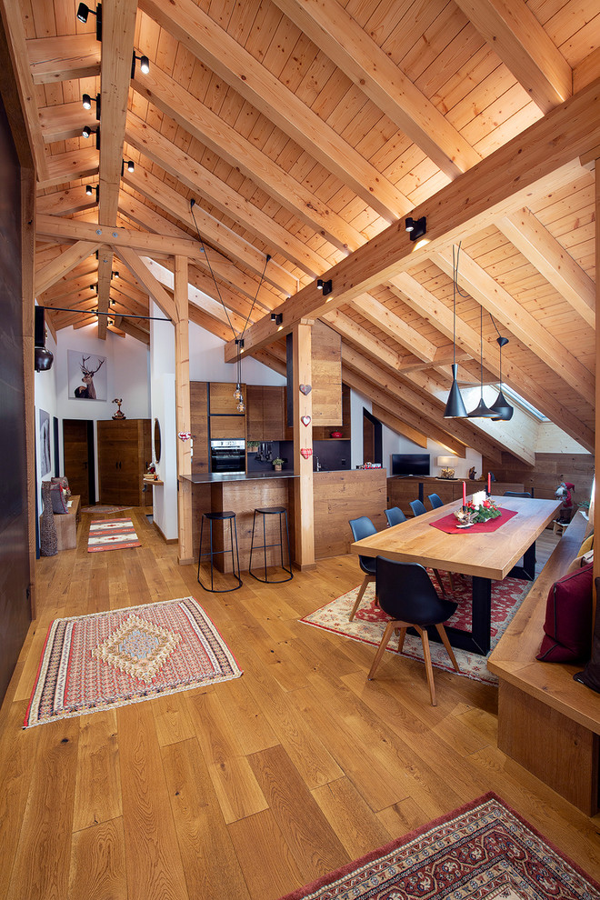 Foto di una sala da pranzo aperta verso la cucina stile rurale con pareti bianche, pavimento in legno massello medio e pavimento marrone