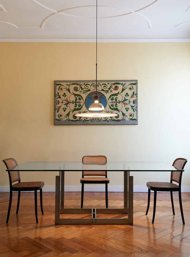 Immagine di una sala da pranzo design chiusa e di medie dimensioni con pareti gialle e pavimento in legno massello medio
