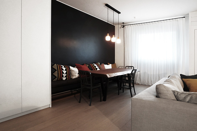 Diseño de comedor contemporáneo grande con paredes negras, suelo laminado y suelo gris