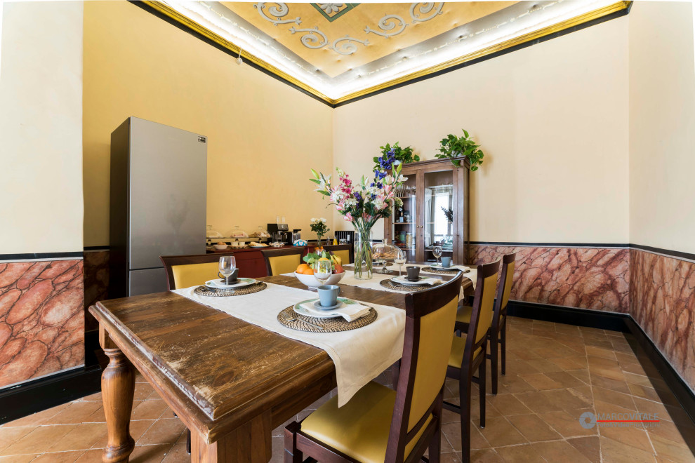 Diseño de comedor clásico grande con paredes multicolor, suelo de baldosas de terracota, suelo naranja y papel pintado