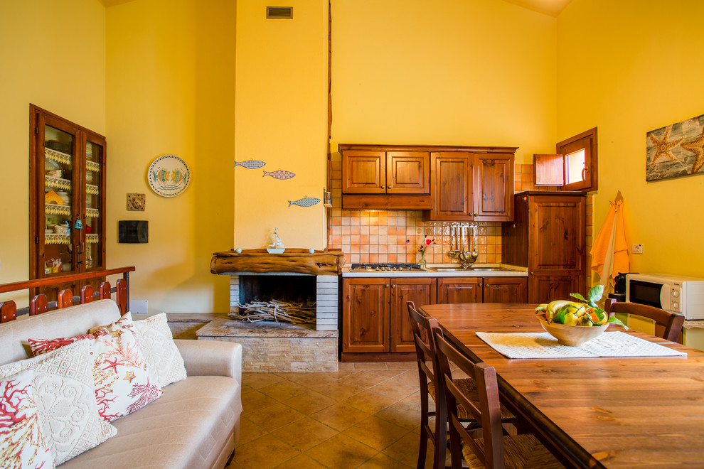 Cette photo montre une salle à manger ouverte sur la cuisine bord de mer avec un mur jaune, un sol en carrelage de porcelaine, une cheminée double-face, un manteau de cheminée en bois et un sol marron.