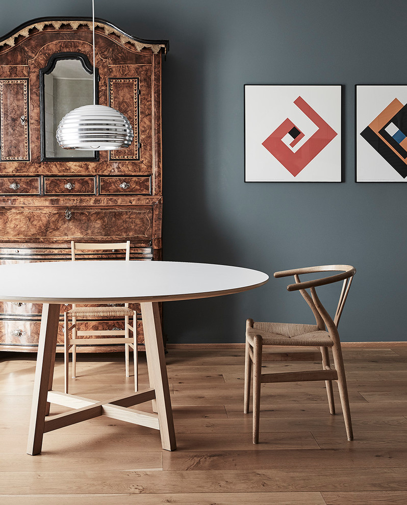 Cette photo montre une salle à manger scandinave avec un mur gris, un sol en bois brun et un sol marron.