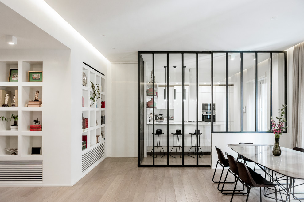This is an example of a contemporary dining room in Rome with white walls, light hardwood flooring and beige floors.