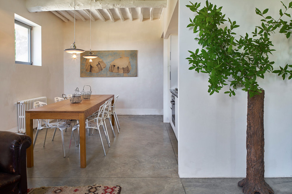 На фото: кухня-столовая среднего размера в средиземноморском стиле с белыми стенами, серым полом и полом из ламината