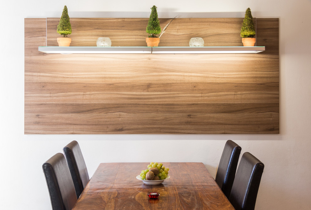 Cette image montre une petite salle à manger ouverte sur la cuisine design avec un mur blanc.