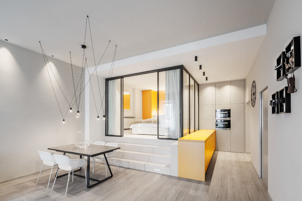 Idee per una sala da pranzo aperta verso il soggiorno design con pareti grigie, parquet chiaro e pavimento beige