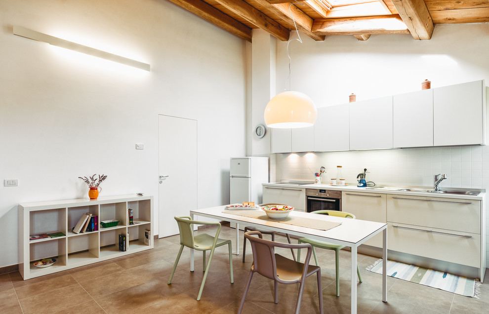 Foto di una grande sala da pranzo aperta verso la cucina moderna con pareti bianche