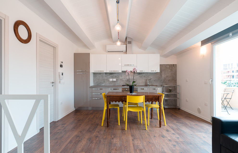 Inspiration pour une salle à manger ouverte sur la cuisine design de taille moyenne avec un mur blanc et parquet foncé.