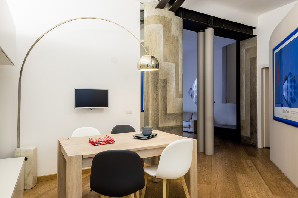 Immagine di una piccola sala da pranzo aperta verso la cucina design con pareti bianche, parquet chiaro e pavimento beige