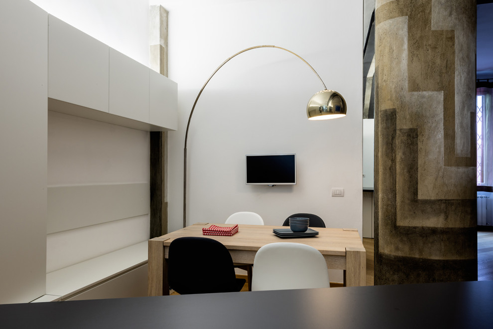 Foto di una piccola sala da pranzo aperta verso la cucina design con pareti bianche, parquet chiaro e pavimento beige