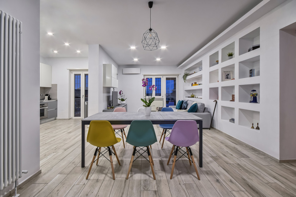 Immagine di una sala da pranzo aperta verso il soggiorno minimal con pareti bianche e pavimento grigio