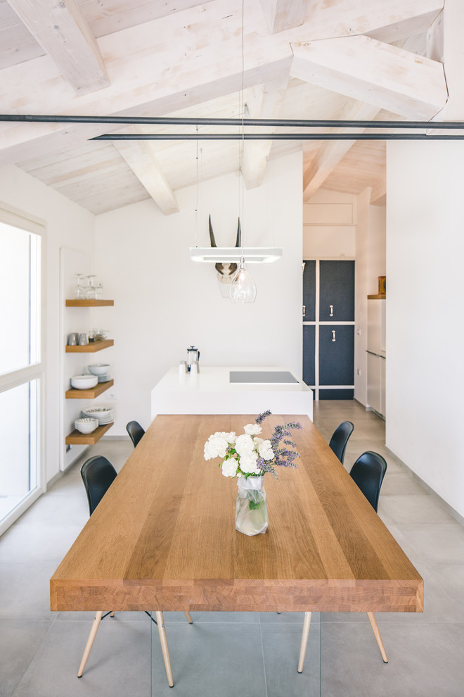 Aménagement d'une salle à manger ouverte sur la cuisine contemporaine avec un mur blanc.