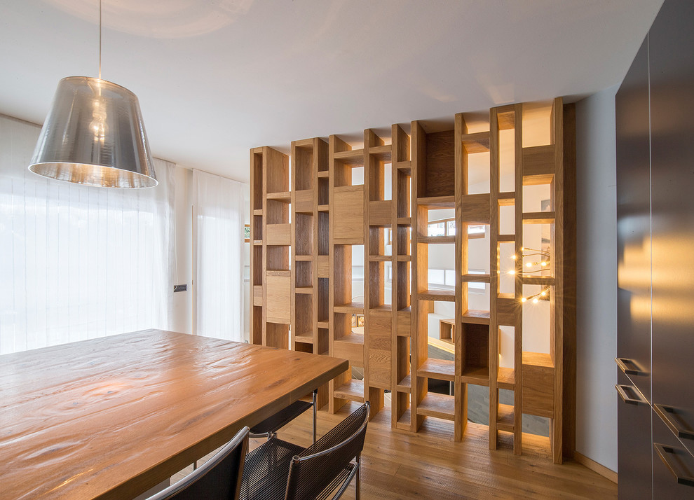 Immagine di una piccola sala da pranzo minimal con pareti bianche, pavimento in legno massello medio e pavimento marrone