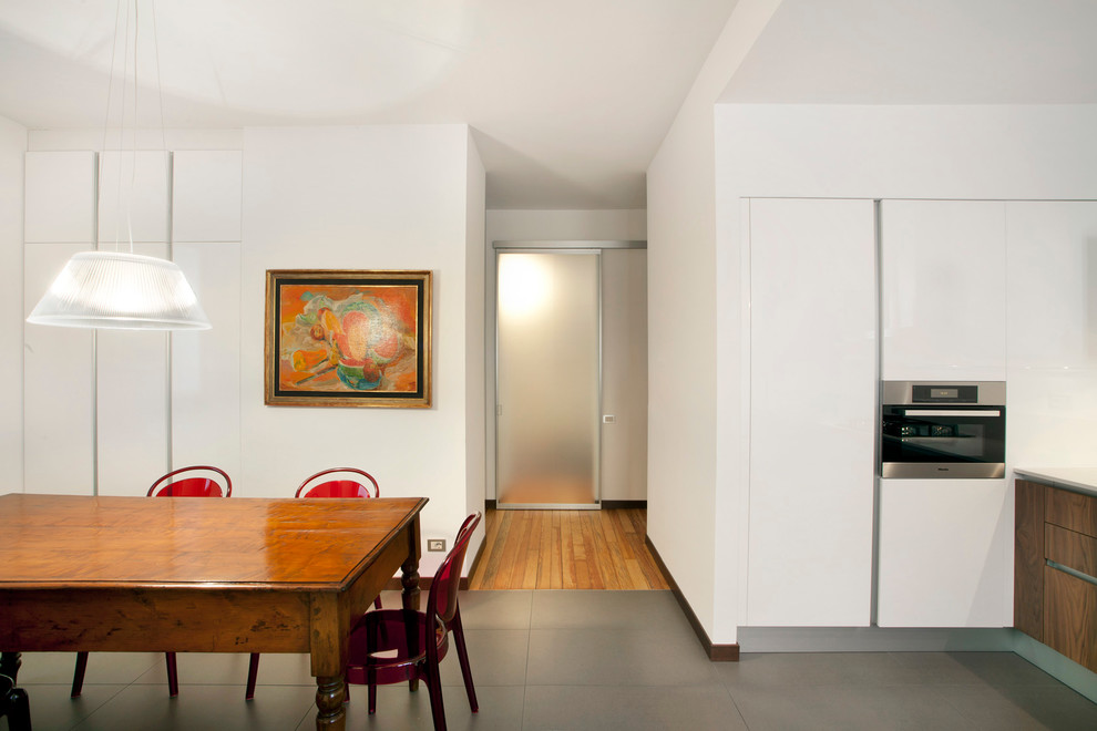 Cette image montre une salle à manger ouverte sur la cuisine minimaliste avec un mur blanc et aucune cheminée.