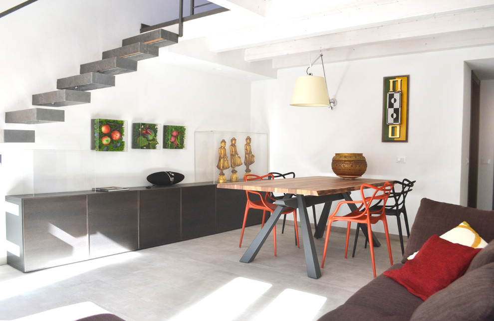 Idee per una grande sala da pranzo aperta verso il soggiorno minimal con pareti bianche, pavimento in gres porcellanato e pavimento grigio