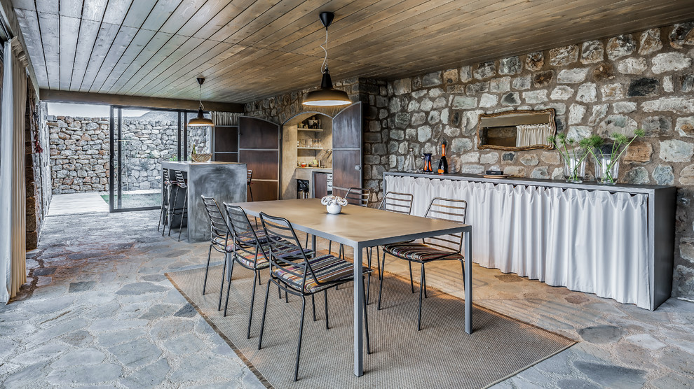 Idee per una sala da pranzo aperta verso la cucina mediterranea con nessun camino e pavimento grigio