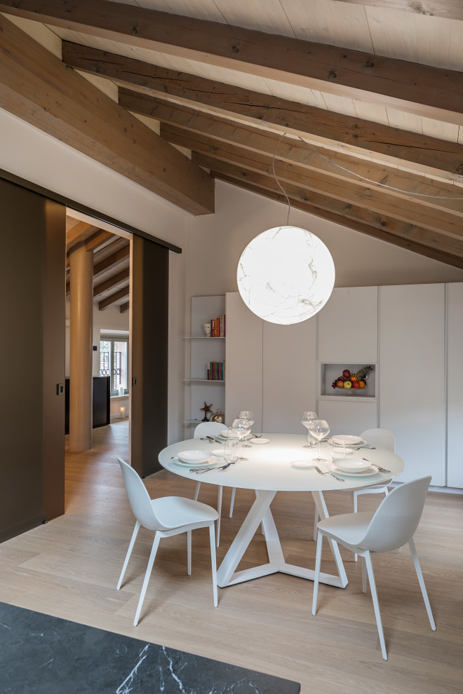 Foto di una sala da pranzo aperta verso la cucina minimal di medie dimensioni con pareti bianche, parquet chiaro e pavimento beige