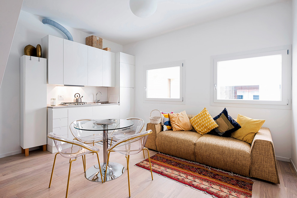 Immagine di una piccola sala da pranzo aperta verso la cucina bohémian con pareti bianche, pavimento in legno massello medio e pavimento marrone