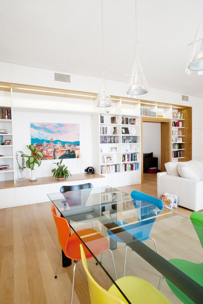 Offenes, Großes Modernes Esszimmer mit braunem Boden, weißer Wandfarbe, hellem Holzboden, Kamin und Kaminumrandung aus Stein in Mailand