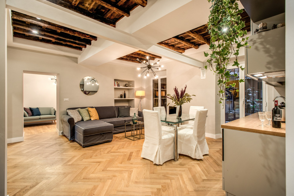 Mittelgroßes Modernes Esszimmer mit grauer Wandfarbe, hellem Holzboden und freigelegten Dachbalken in Rom
