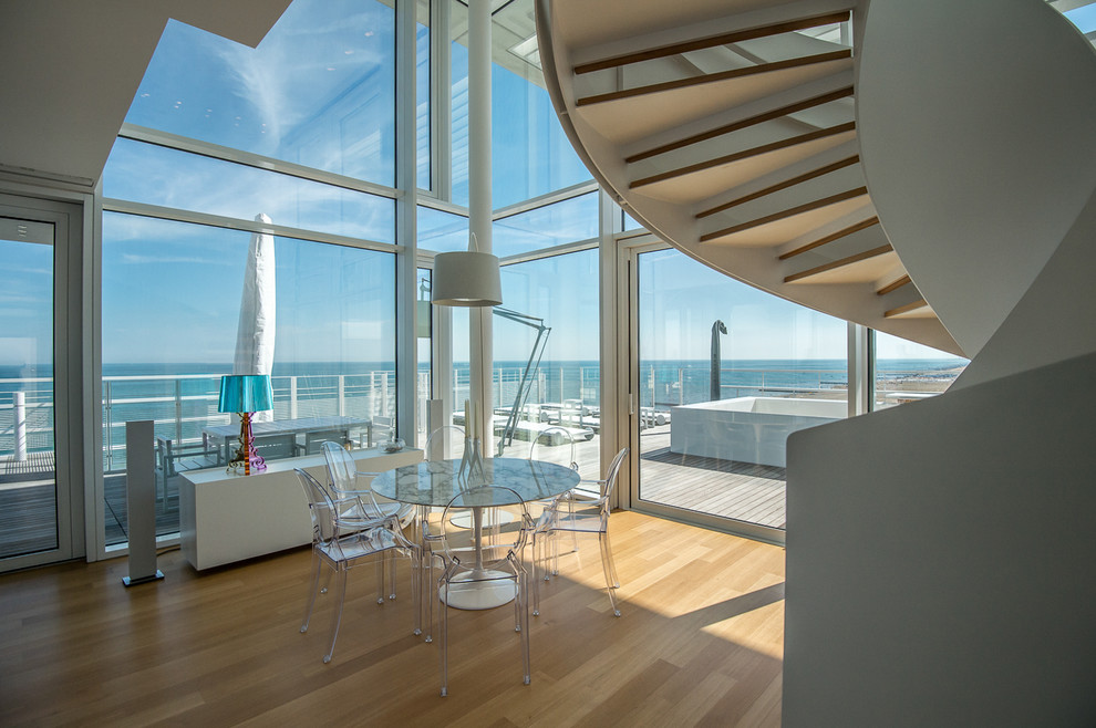 Esempio di una sala da pranzo aperta verso il soggiorno costiera con parquet chiaro