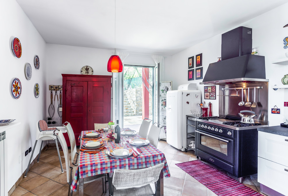 Idée de décoration pour une salle à manger ouverte sur la cuisine champêtre avec un mur blanc et un sol marron.