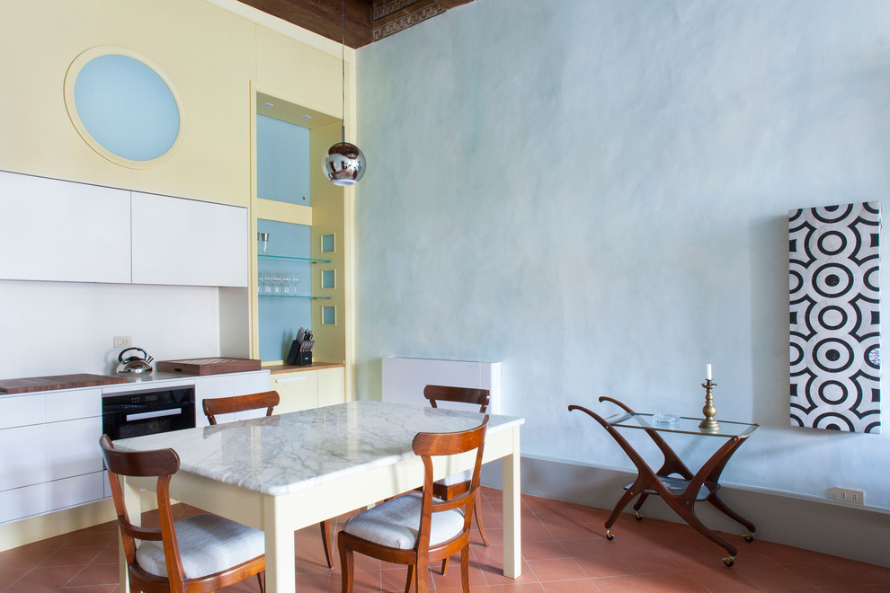 Foto di una sala da pranzo aperta verso la cucina design con pareti blu, pavimento in terracotta e pavimento rosso