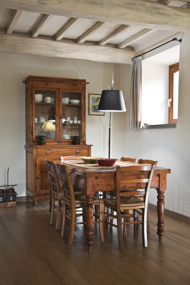フィレンツェにある低価格の中くらいなラスティックスタイルのおしゃれなLDK (白い壁、淡色無垢フローリング、横長型暖炉、漆喰の暖炉まわり、茶色い床、表し梁) の写真