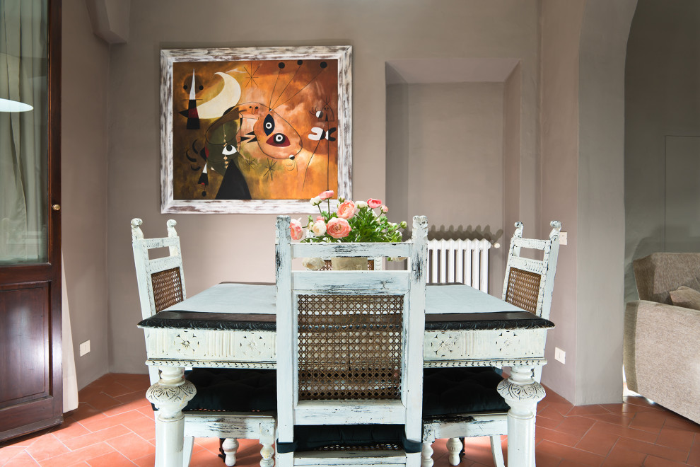 Foto di una piccola sala da pranzo aperta verso il soggiorno minimalista con pareti grigie, pavimento in terracotta e pavimento arancione