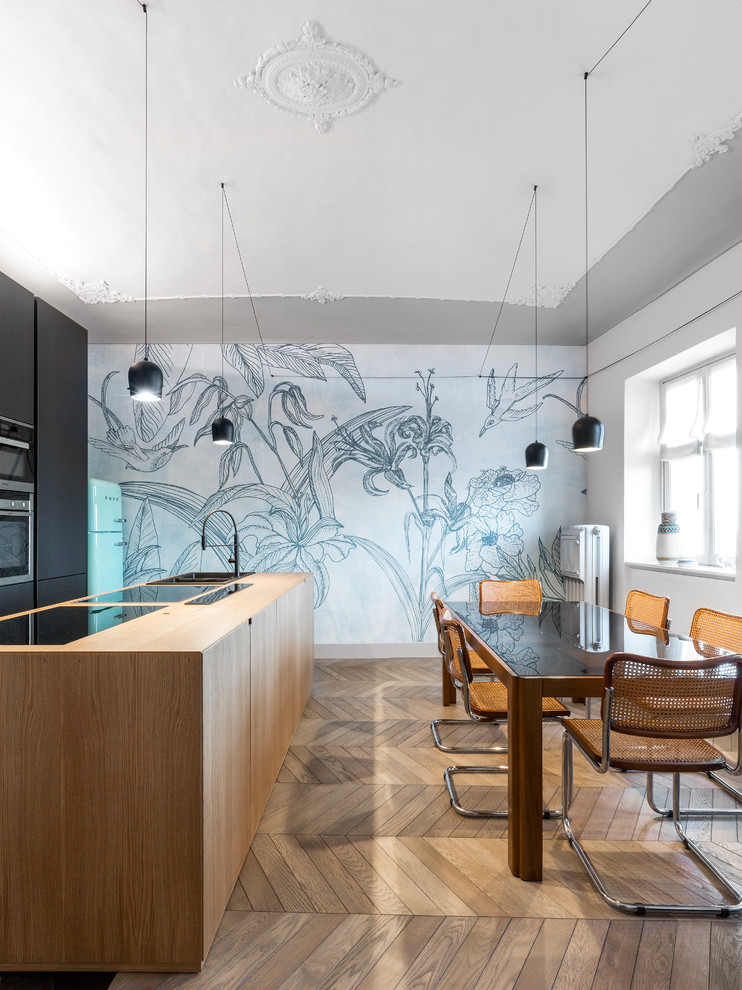 Immagine di una sala da pranzo aperta verso la cucina minimal con pareti grigie, pavimento in legno massello medio e pavimento marrone