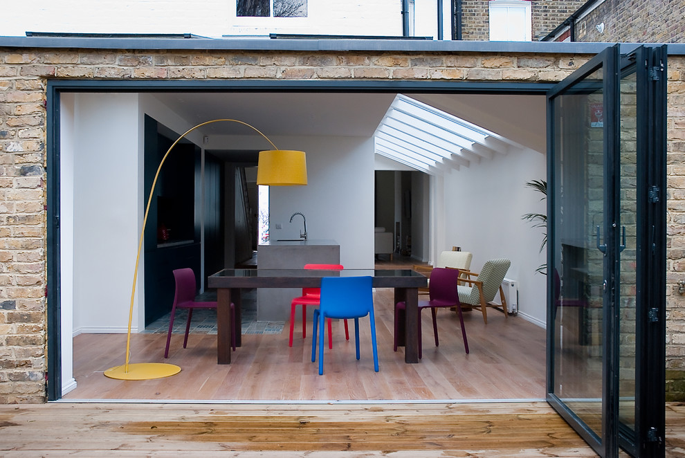 This is an example of a medium sized modern open plan dining room in London with white walls.