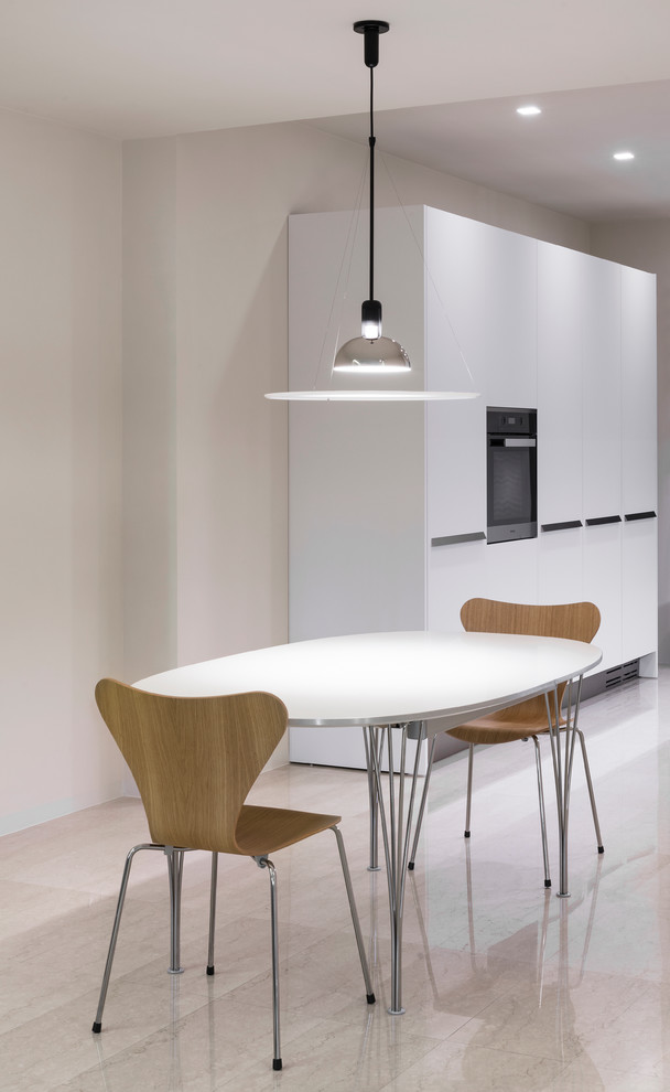 Пример оригинального дизайна: кухня-столовая в стиле модернизм с белыми стенами и мраморным полом