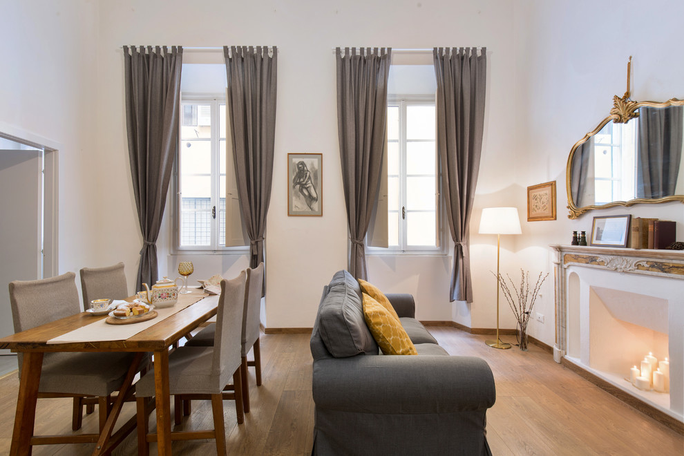 Aménagement d'une salle à manger contemporaine avec un mur blanc, un sol en bois brun, une cheminée standard, un sol marron et éclairage.