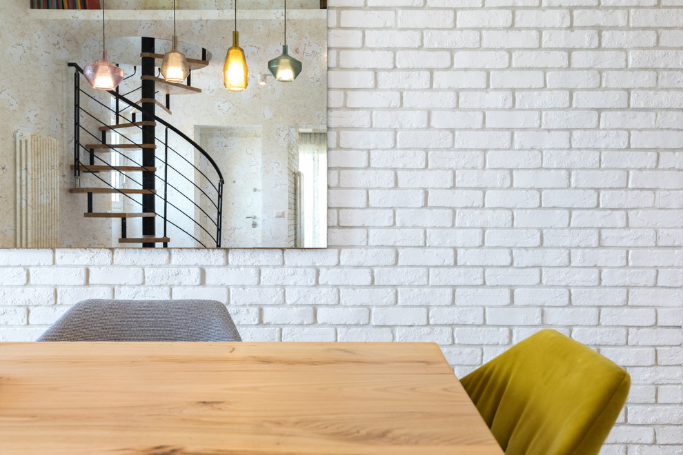 Ejemplo de comedor urbano con paredes blancas y suelo de madera clara