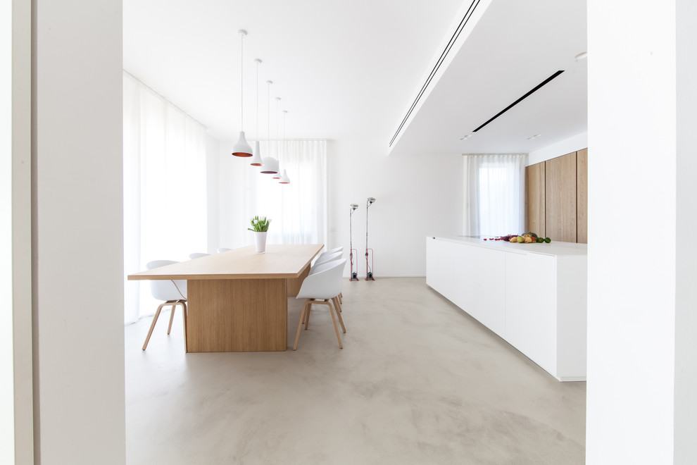 Immagine di una grande sala da pranzo aperta verso la cucina design con pavimento grigio e pavimento in cemento