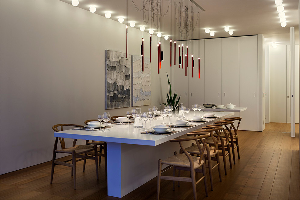 Стильный дизайн: отдельная столовая в современном стиле с белыми стенами и паркетным полом среднего тона - последний тренд