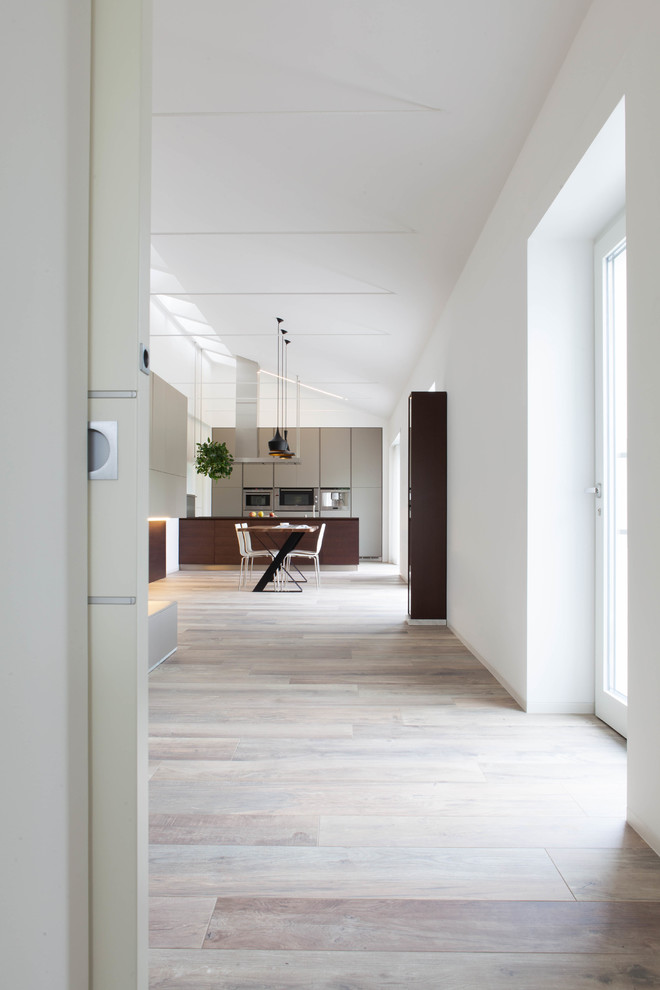 Ispirazione per una grande sala da pranzo aperta verso il soggiorno minimalista con pareti bianche, pavimento in legno massello medio, nessun camino e pavimento beige