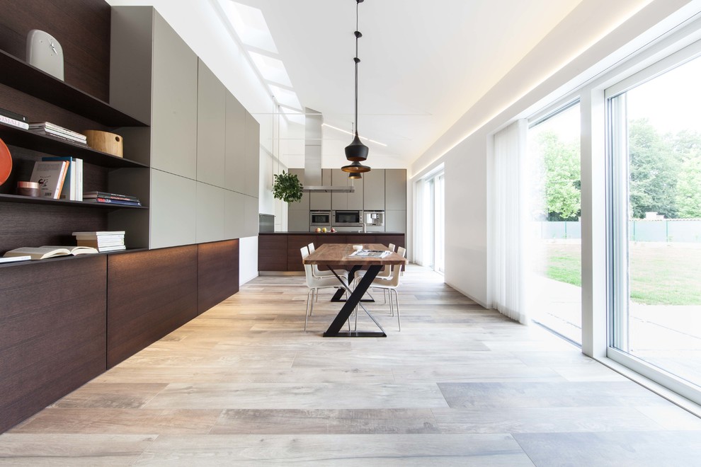 Ispirazione per una grande sala da pranzo aperta verso la cucina minimalista con pareti bianche, pavimento in legno massello medio, nessun camino e pavimento beige