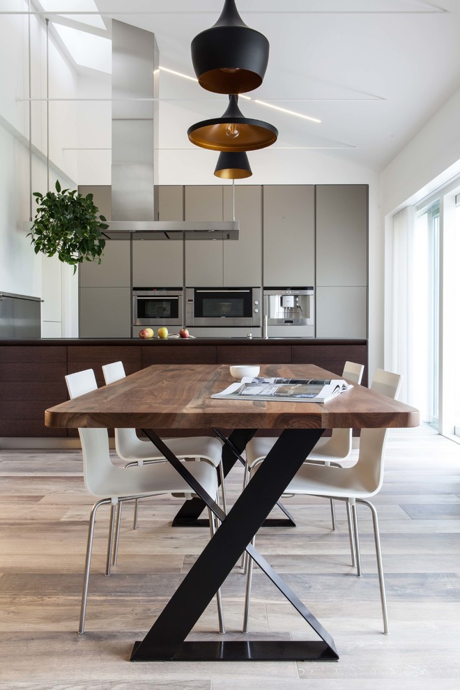 Aménagement d'une grande salle à manger ouverte sur la cuisine moderne avec un sol en bois brun.