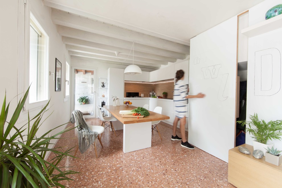 This is an example of a scandinavian kitchen/dining room in Venice with white walls.